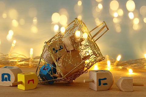 This is a stock photo. A dreidel surrounded by twinkling lights.